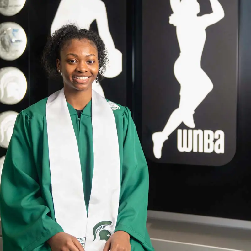 Women's basketball player in cap and gown