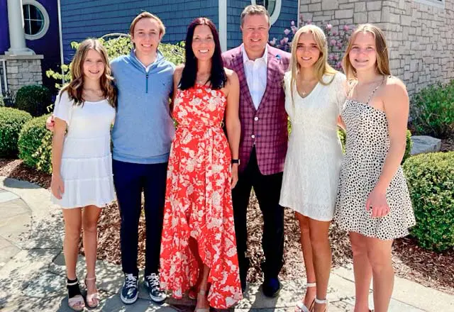 the zeigler family posing in front of a house