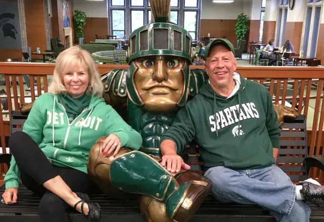 Steve Mellos and Linda Reist sitting with statue of sparte