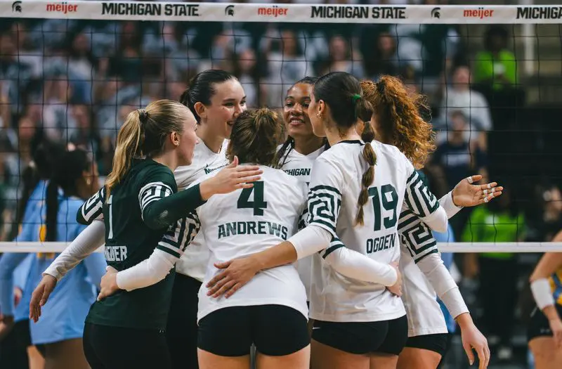 Volleyball players raising hands together